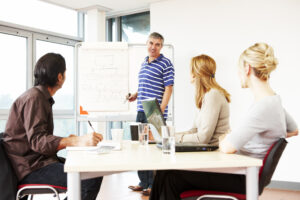 mature businessman giving presentation to his team