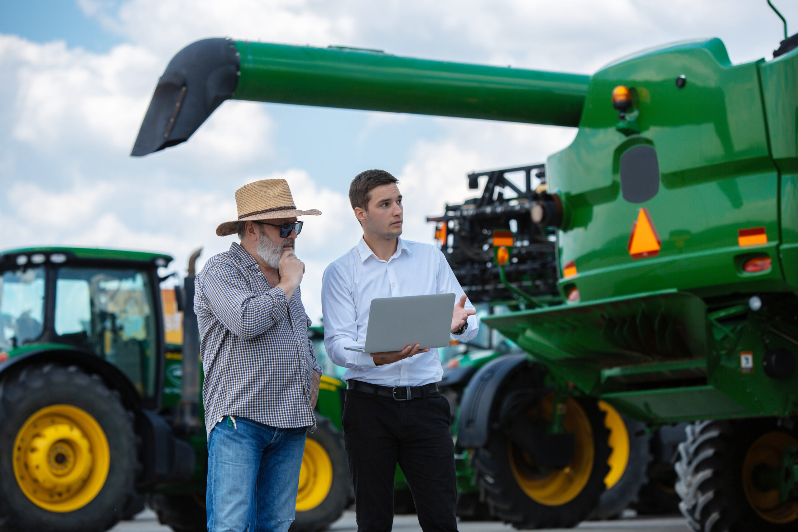 Agricultor moderno con ordenador y señor enseñandole